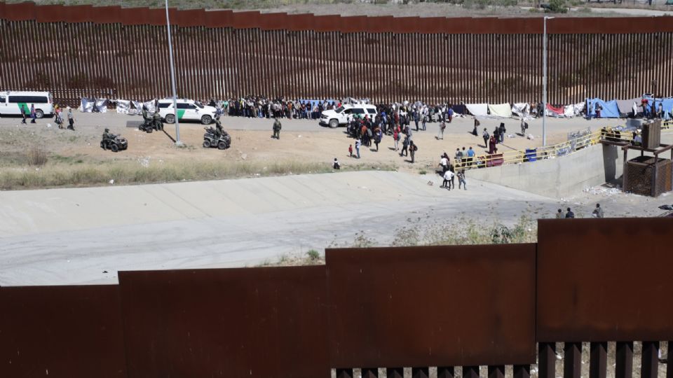 Migrantes de diversas nacionalidades acampan junto al muro fronterizo estadounidense.