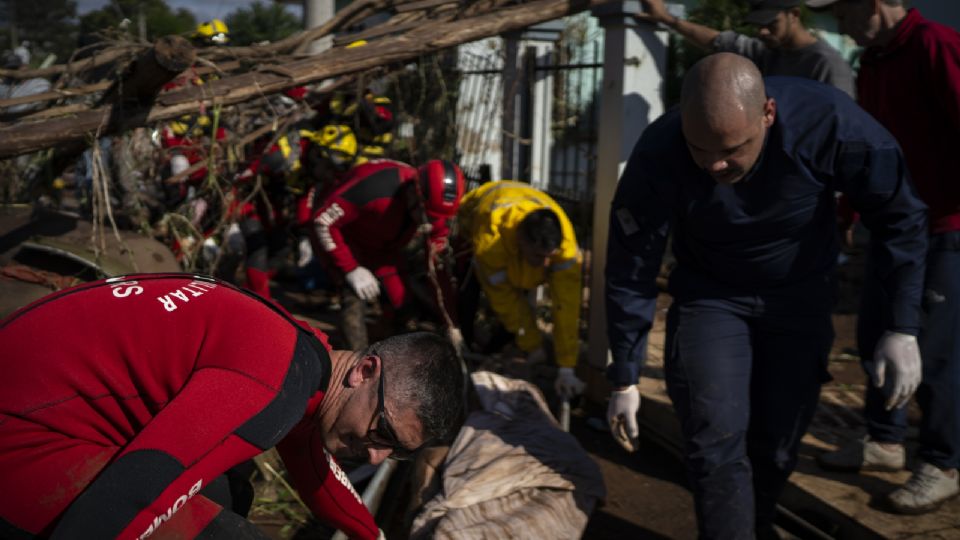 Bomberos retiran el cuerpo de una persona fallecida tras el paso de un ciclón extratropical.
