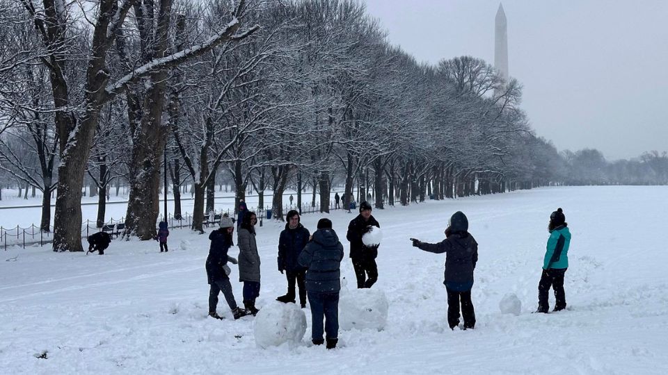 Transeúntes arman muñecos de nieve durante una nevada en la explanada del National Mall hoy, en el centro de Washington.