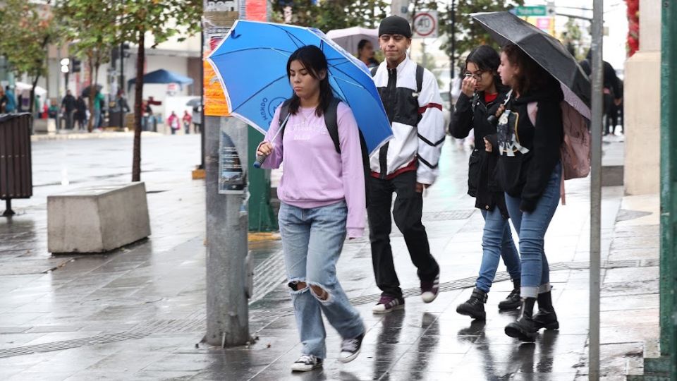 Ciudadano camina en el centro de Monterrey, con frío y lluvia de por medio