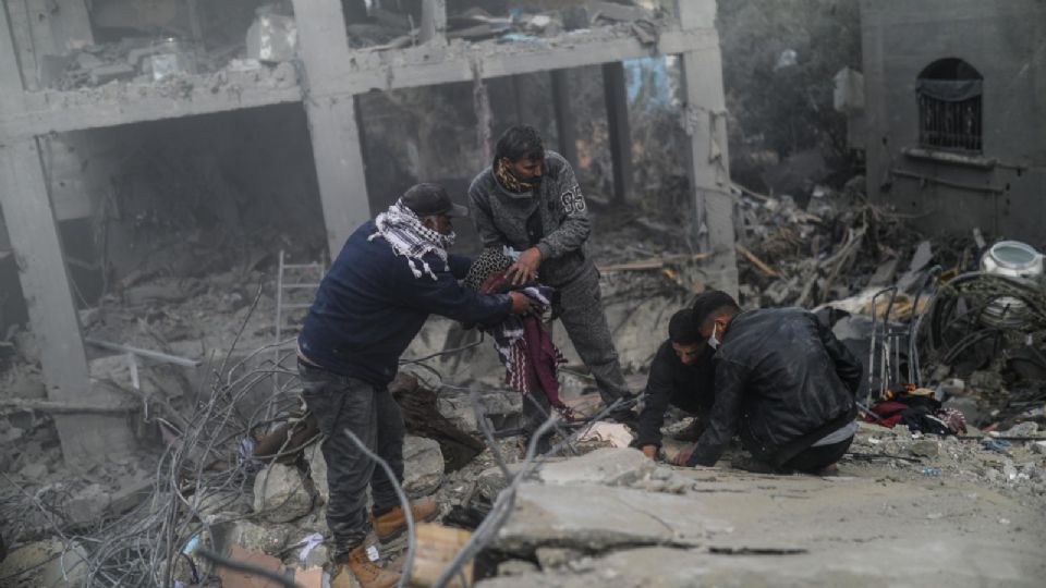 Palestinos buscan supervivientes entre los escombros de una casa destruida tras un ataque aéreo israelí,  sur de la Franja de Gaza.