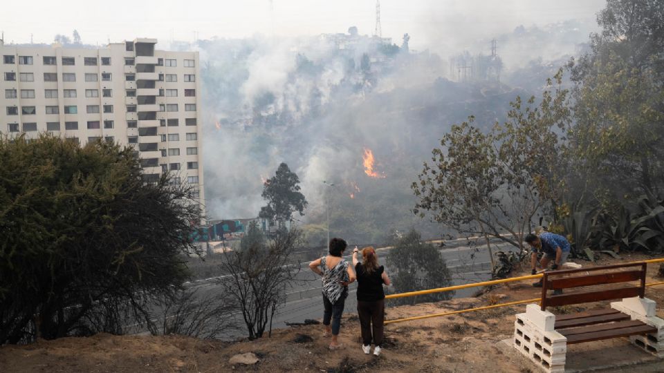 Mujeres observan los estragos de uno de los incendios en Chile.