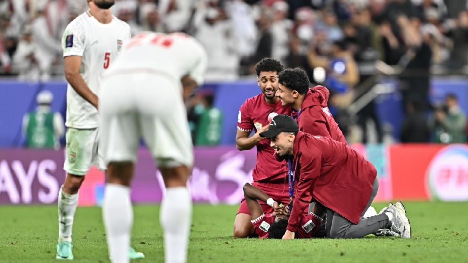 Los jugadores de la Selección de Qatar celebran el triunfo, mientras que algunos jugadores de Irán lamentan la derrota