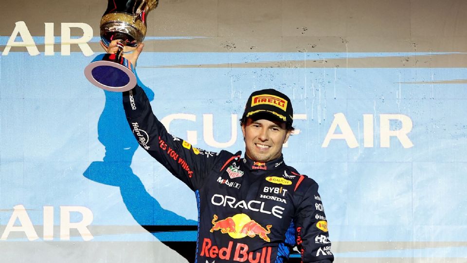 El piloto mexicano Sergio Pérez, de Red Bull Racing, que quedó en segundo lugar, levanta su trofeo en el podio durante la ceremonia de victoria del Gran Premio de Baréin de Fórmula 1.