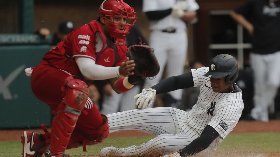 El jugador de los Yankees de Nueva York, Oscar González (d) en acción ante el catcher José Briseño (i) de los Diablos Rojos de México