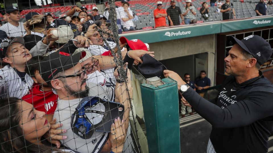 El manager Aaron Boone, de los Yankees de Nueva York, firma autógrafos previo a un juego amistoso entre los Yankees de Nueva York y Diablos Rojos del México