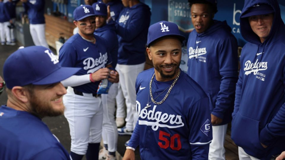 El segunda base de los Dodgers de Los Ángeles, Mookie Betts (C), habla con sus compañeros de equipo