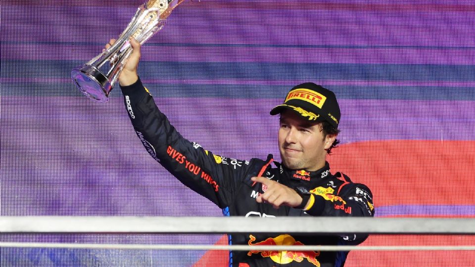 El piloto mexicano Sergio Pérez, de Red Bull Racing, que quedó en segundo lugar, celebra con el trofeo en el podio después del Gran Premio de Arabia Saudita de Fórmula 1.