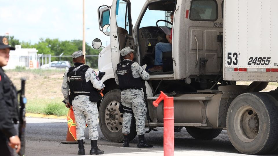 Elementos de la Guardia Nacional abordan a trailero