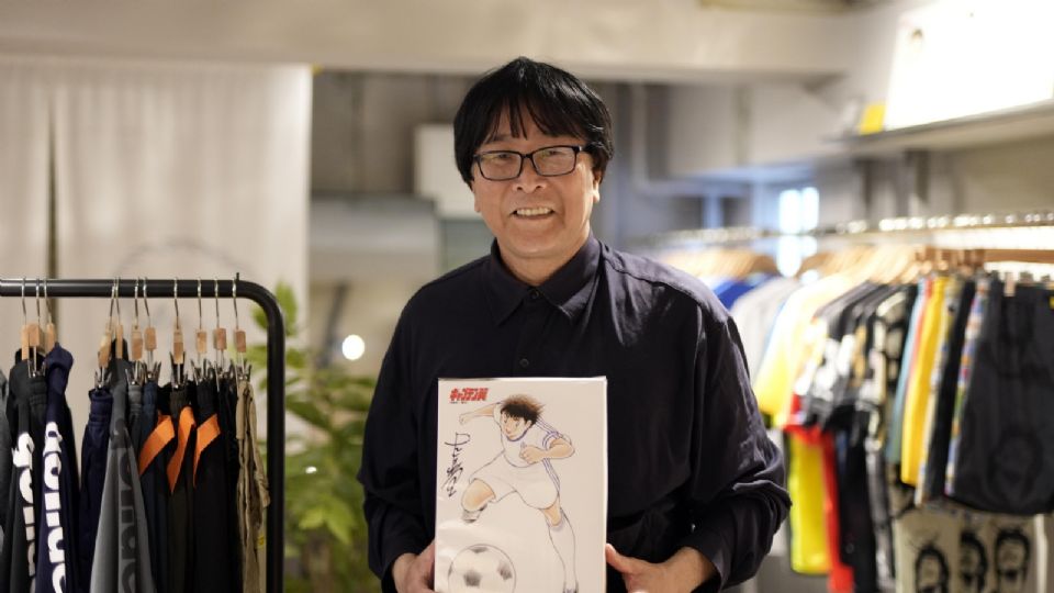 El artista de manga Yoichi Takahashi posa con una obra de arte a la venta en la tienda 'gol. Store Tsubasa' en Tokio, Japón.