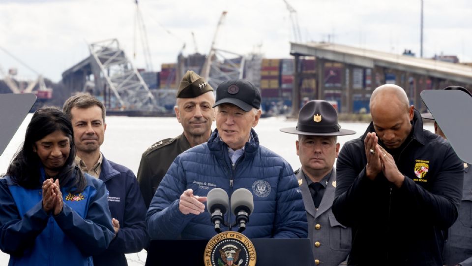 El presidente de Estados Unidos, Joe Biden (C), pronuncia comentarios cerca de los restos del Puente Francis Scott Key, en el fondo, mientras está parado junto al gobernador de Maryland, Wes Moore (R), el secretario de Transporte de Estados Unidos, Pete Buttigieg (2-L), entre otros, en Dundalk, Maryland, Estados Unidos, el 5 de abril de 2024.