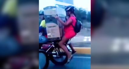 Captan a mujer embarazada y su pareja trasladando electrodoméstico en moto