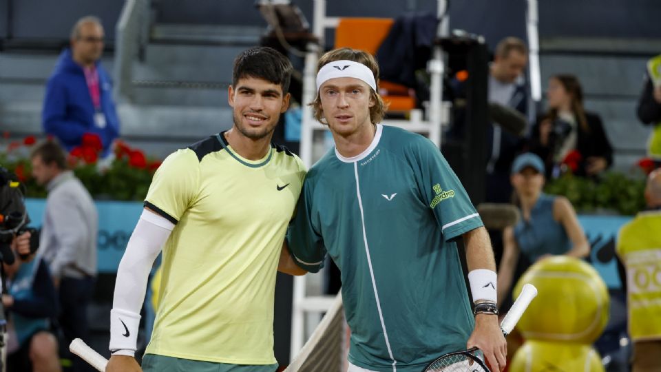 El tenista español Carlos Alcaraz (i) posa con el ruso Andréi Rublev, antes de su partido en cuartos de final del Mutua Madrid Open