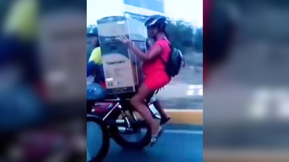 Captan a mujer embarazada sosteniendo electrodomésticos en moto