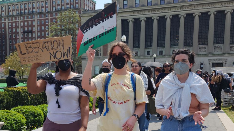 Una estudiante sostiene un cartel con la bandera de Palestina al interior de la Universidad de Columbia.