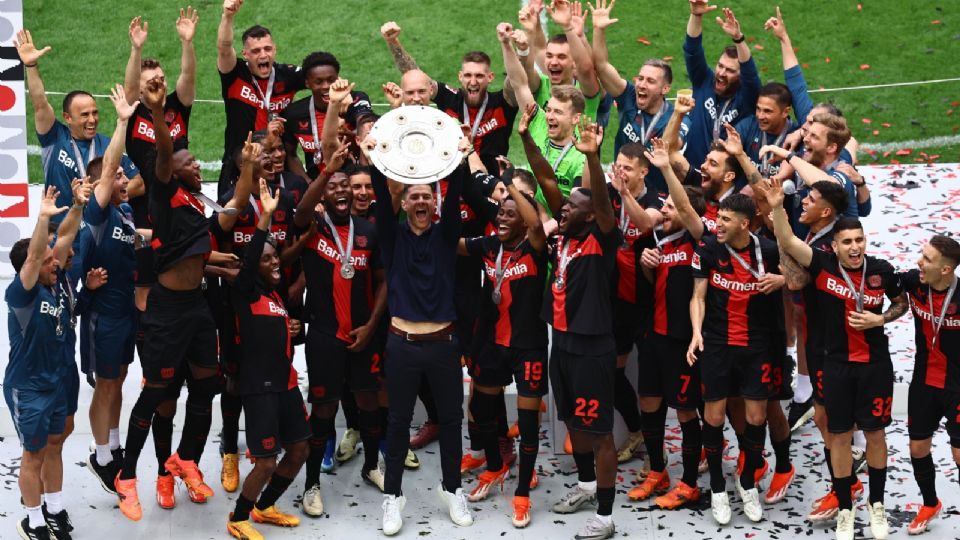 Los jugadores del Bayer Leverkusen celebran mientras el entrenador Xabi Alonso (C) levanta el trofeo de la Bundesliga después del partido ante el FC Augsburg.