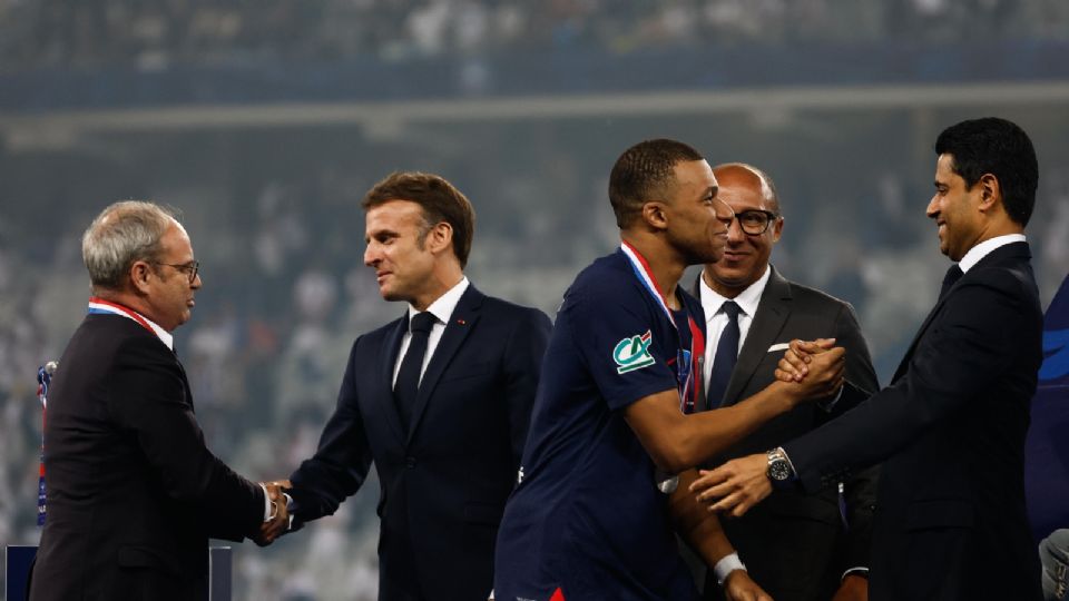 El director general del París Saint Germain, Nasser Al Khelaifi (R), estrecha la mano de Kylian Mbappe (C) durante la ceremonia de la Coupe de France.