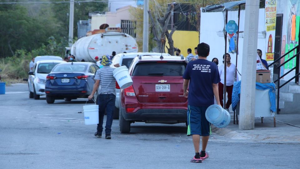 Ciudadanos cargan botes con agua en la zona metropolitana