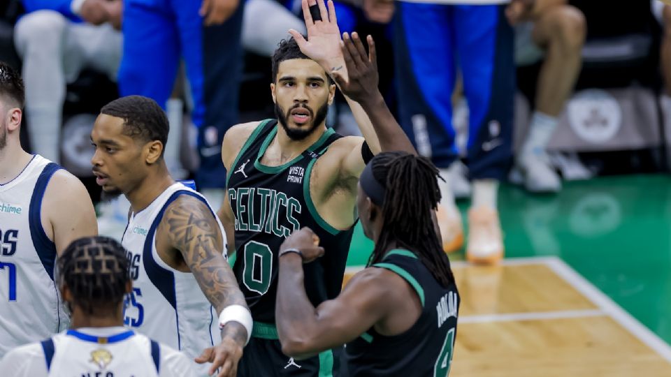 El alero de los Boston Celtics, Jayson Tatum (C), reacciona con el base, Jrue Holiday (R), durante el juego dos de las Finales de la NBA entre los Boston Celtics y los Dallas Mavericks.