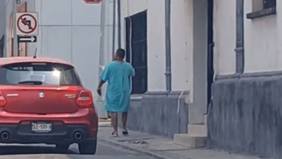 Hombre con bata de hospital caminando por el centro de Monterrey