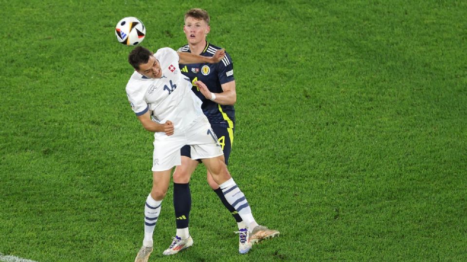 Vincent Sierro de Suiza en acción contra Scott McTominay de Escocia.