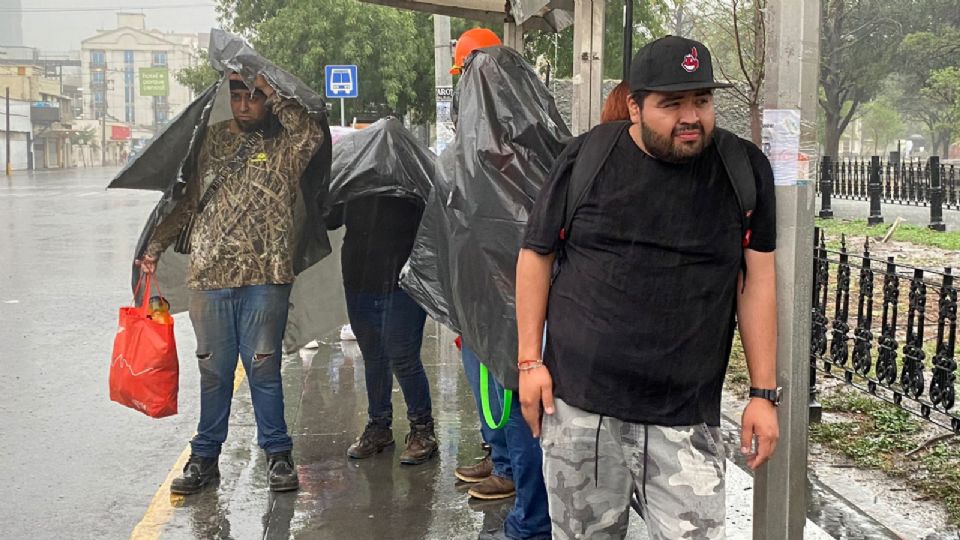 Ciudadanos de Monterrey esperan el camión en medio del ciclón Alberto.