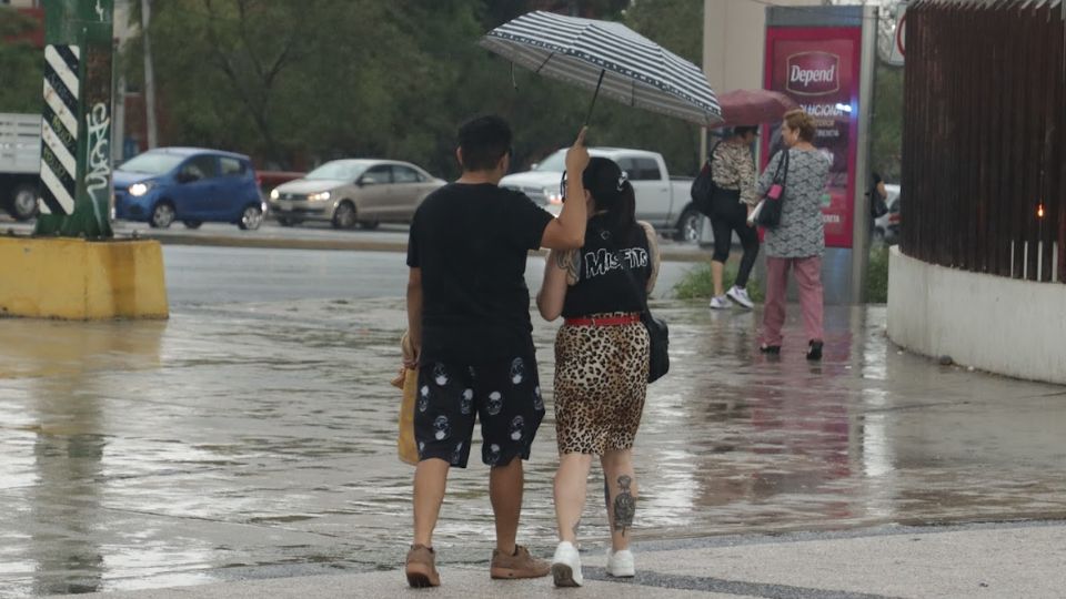 Pareja camina bajo la lluvia en Monterrey