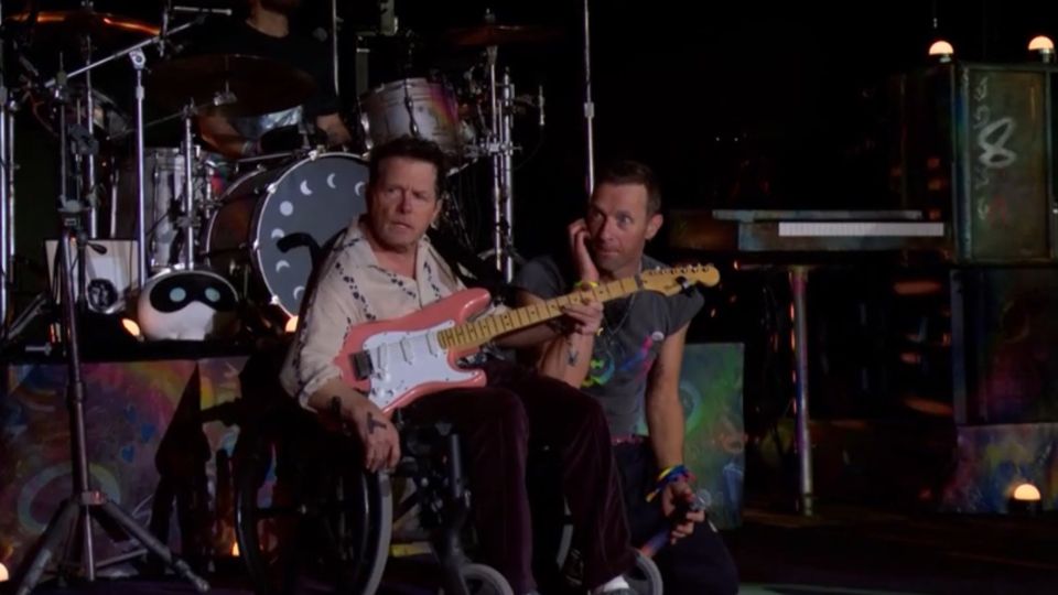 Chris Martin (derecha) y Michael J. Fox en el escenario de Glastonbury