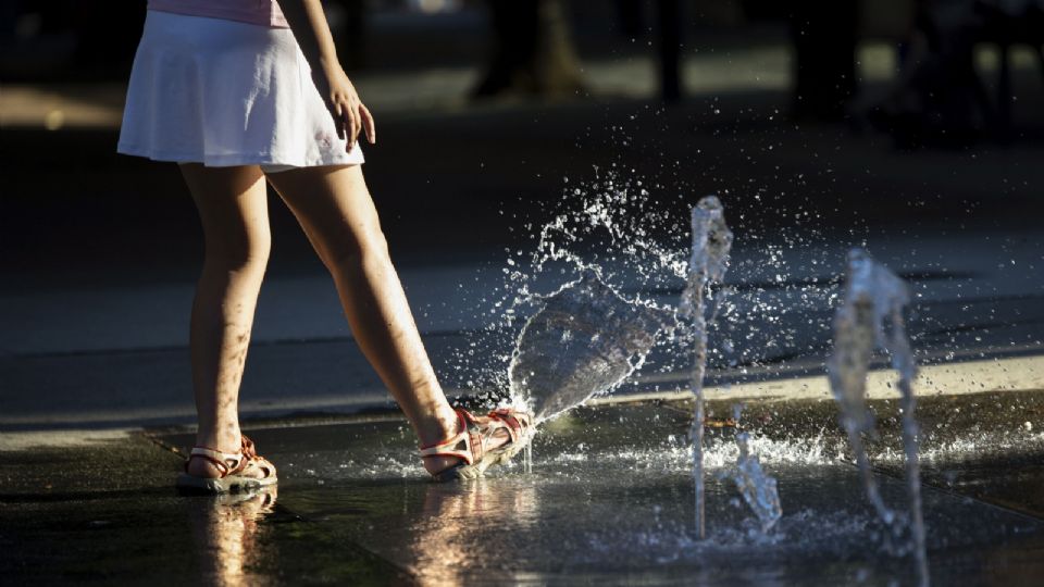 Una joven refresca los pies en una fuente ante las altas temperaturas