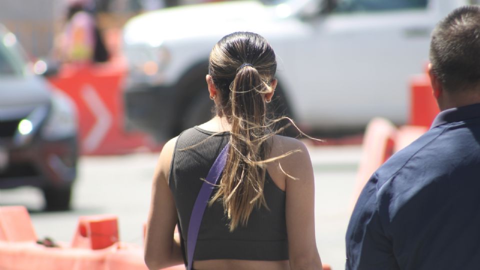 Joven pasea por calles del centro mientras fuertes vientos hacen de las suyas con su cabello