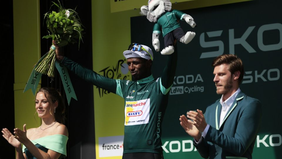 El ciclista eritreo Biniam Girmay celebra en el podio, luciendo la camiseta verde del mejor sprinter, tras su victoria en la 12ª etapa del Tour de Francia 2024.