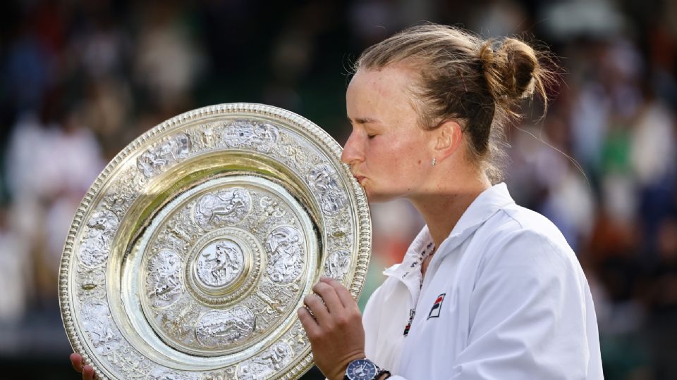 Barbora Krejcikova besa su trofeo después de ganar contra Jasmine Paolini en Wimbledon.