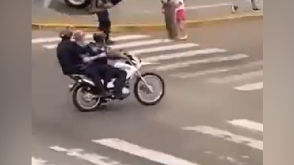 El hombre detenido fue llevado por policías a bordo de una motocicleta.