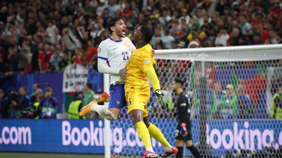 Theo Hernandez (Izq.) y Mike Peterson Maignan (Der.) celebran después de ganar la tanda de penales del partido de cuartos de final de la EURO 2024 entre Francia y Portugal.