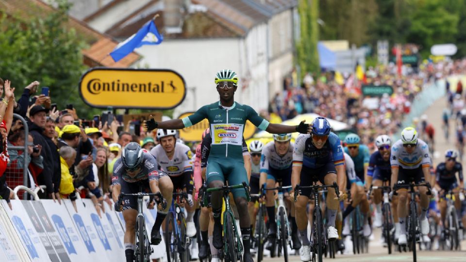 El eritreo Biniam Girmay (C) celebra al cruzar la línea de meta para ganar la octava etapa del Tour de Francia 2024.