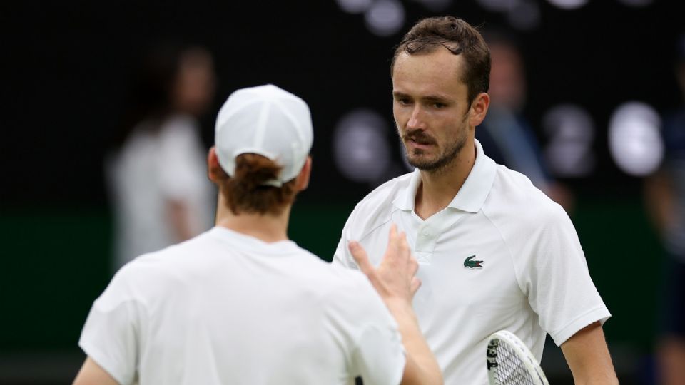 Daniil Medvedev es felicitado en la red por Jannik Sinner después de ganar su partido de cuartos de final en Wimbledon.