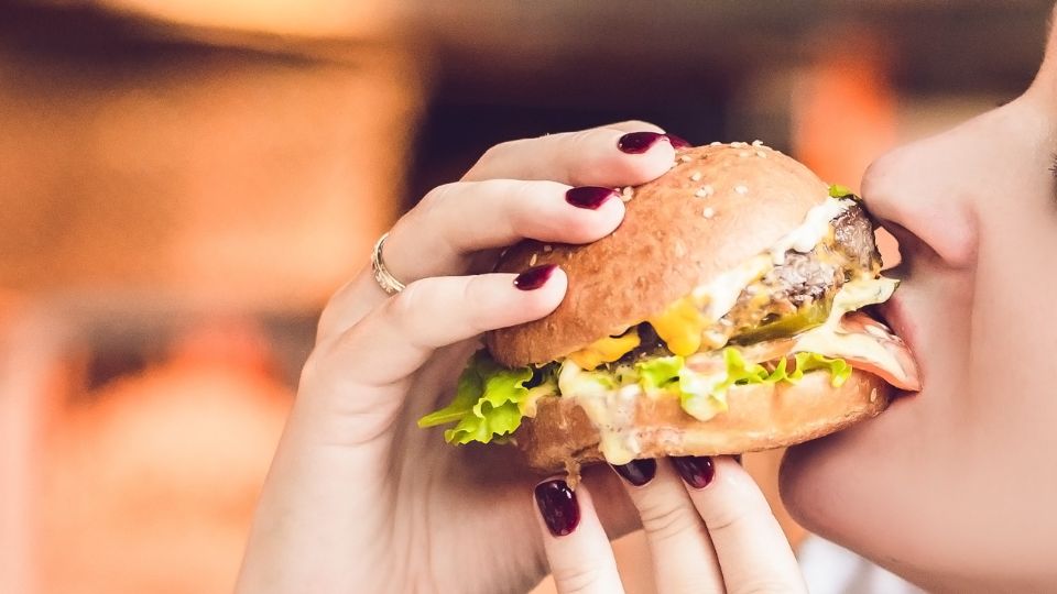 Joven degusta una hamburguesa