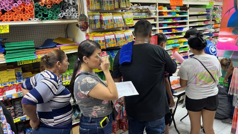 Personas comprando útiles escolares.