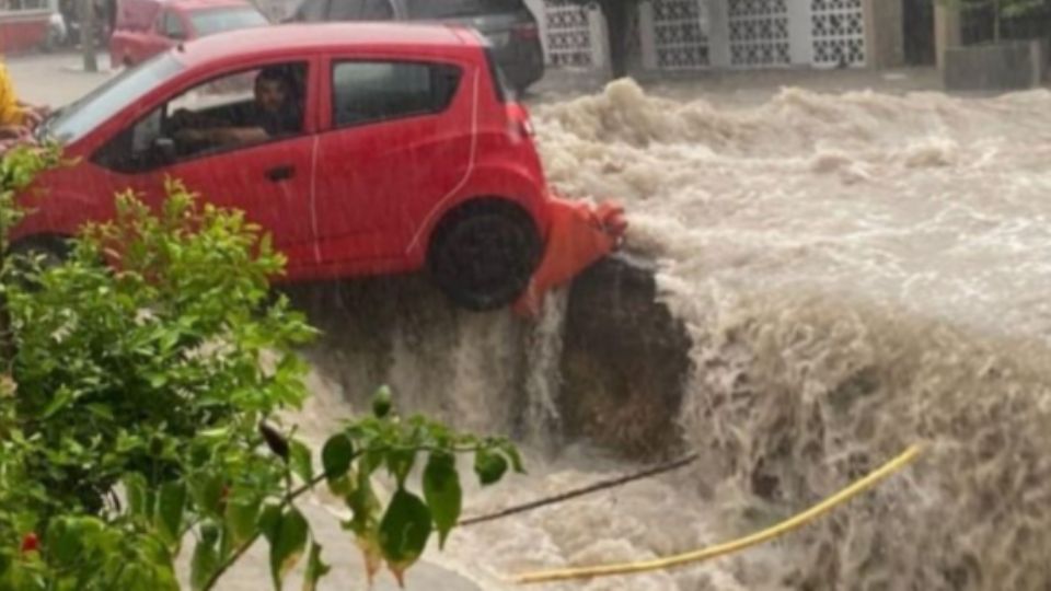 Rescatan a conductor de vehículo varado en una inundación en Monterrey.