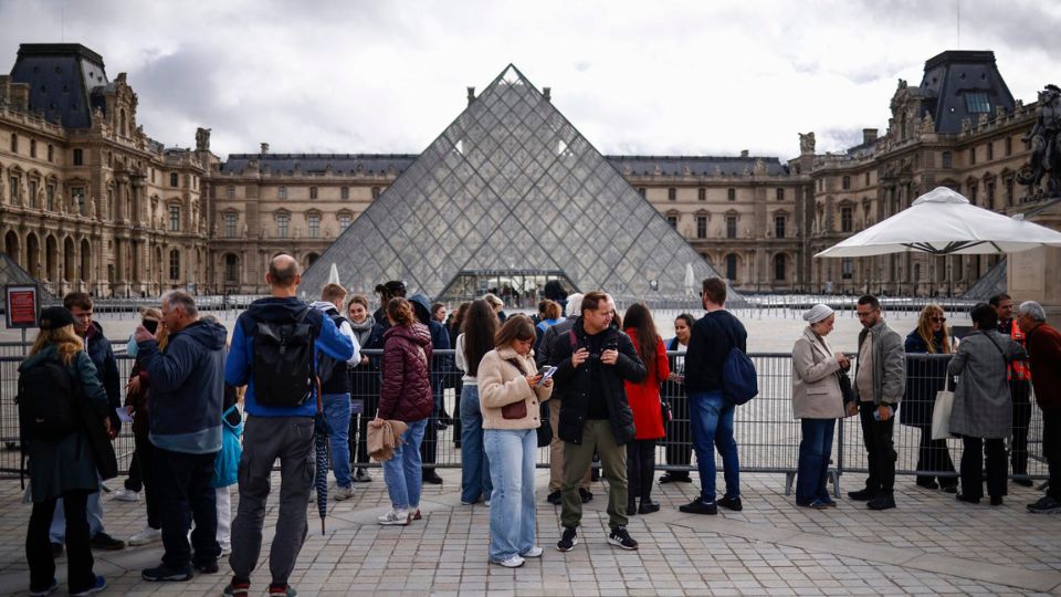 Visitantes permanecen en el exterior del Museo del Louvre, cerrado, un día después de un robo en París, Francia