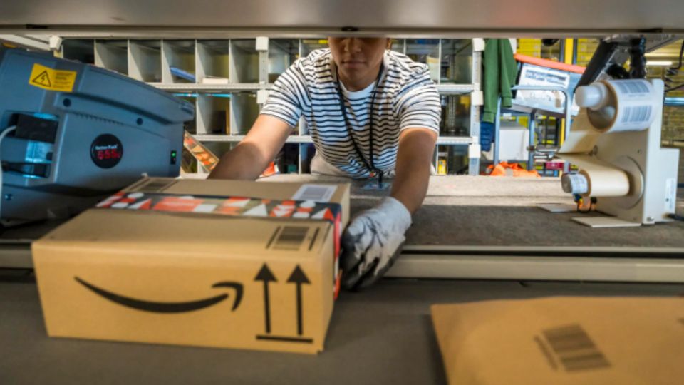 Empleado de Amazon preparando un paquete para ser enviado a su destinatario