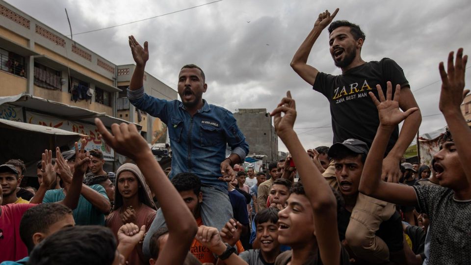 Palestinos desplazados internos celebran el anuncio de un acuerdo de alto el fuego entre Hamás e Israel en Jan Yunis.
