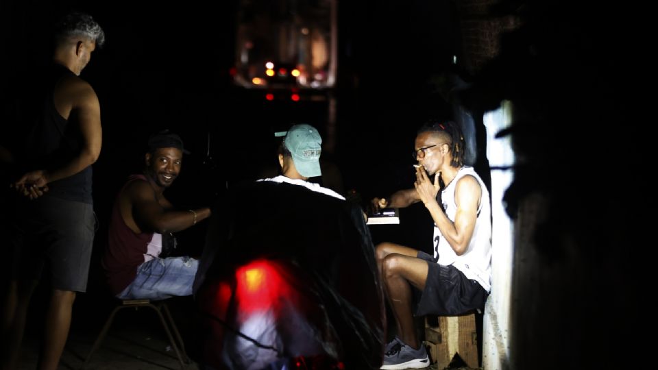 Personas conversan durante un apagón este viernes, en La Habana, (Cuba).