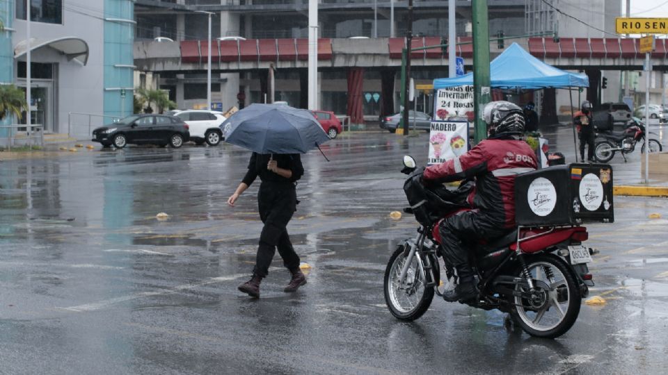 Persona caminando por el centro de la ciudad con una paragua para protegerse de la lluvia