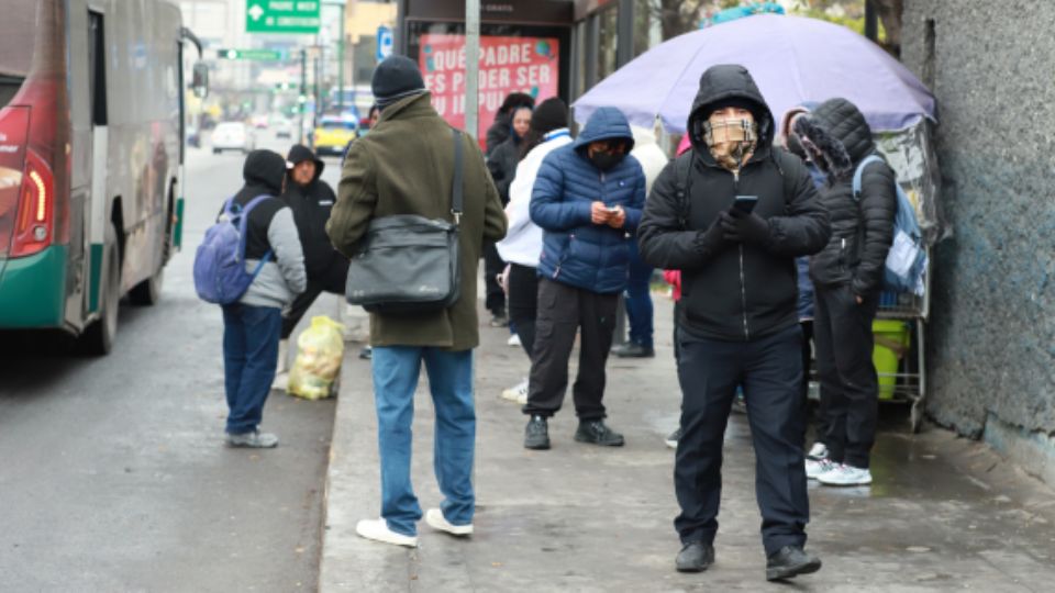 Personas esperando el transporte público en Monterrey durante la temporada invernal.