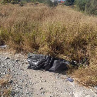 Hallan cuerpo envuelto en bolsas negras en terreno baldío de García