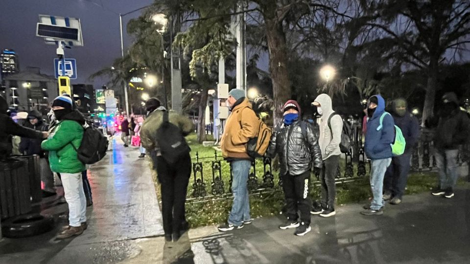 Personas aguardan por su camión en La Alameda