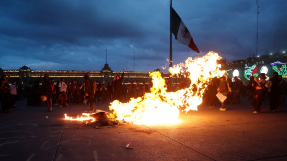 Encapuchados incendian objetos en el Zócalo capitalino.