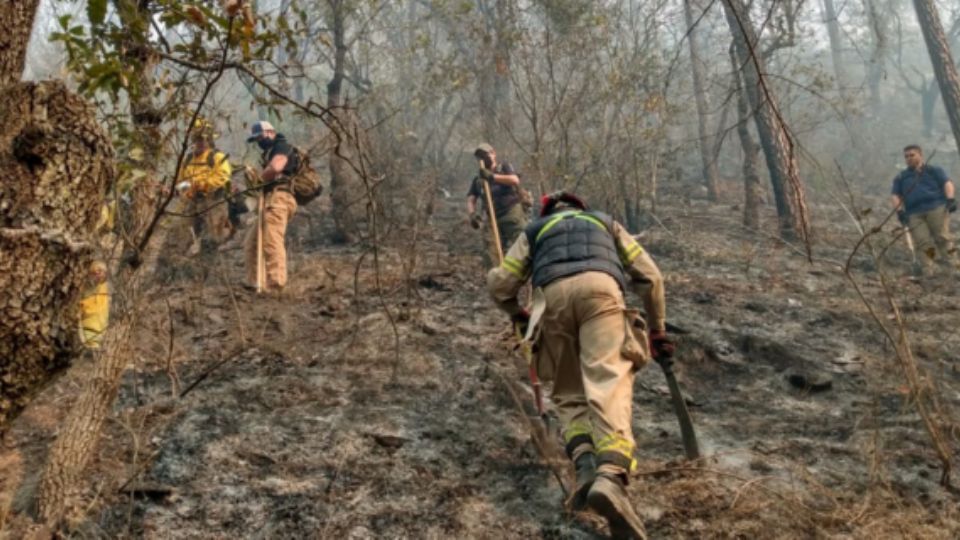 Elementos de bomberos sofocando incendio.