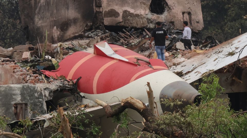 Los oficiales observan los restos del avión siniestrado en la ciudad de Ahmedabad, Gujarat, India este viernes